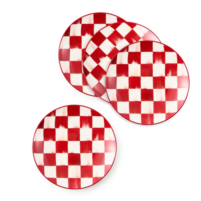 Four round appetizer plates with a red and white hand-painted checkered pattern.