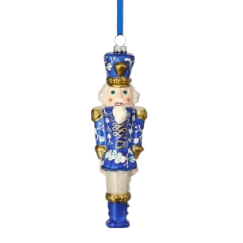Blue and white glass toy soldier ornament with gold accents and a blue hanging ribbon.
