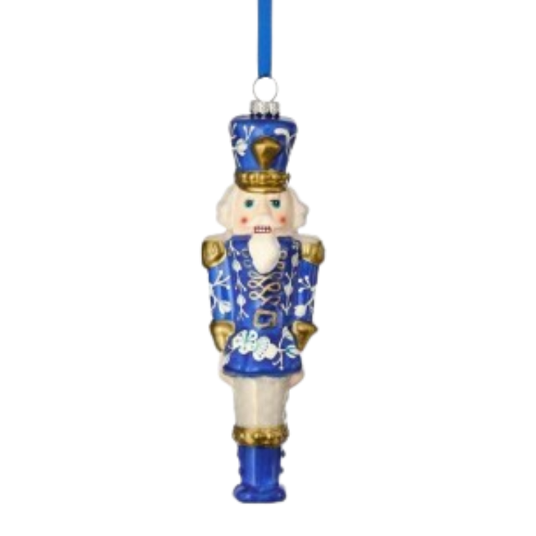 Blue and white glass toy soldier ornament with gold accents and a blue hanging ribbon.