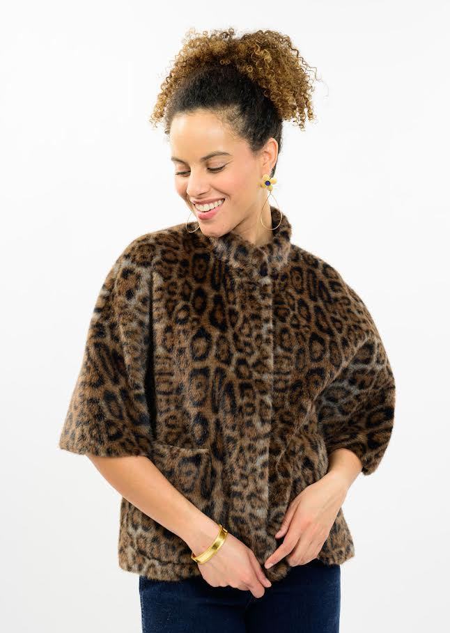 Woman wearing a Megan Faux Fur Capelet in a brown leopard print with short sleeves.