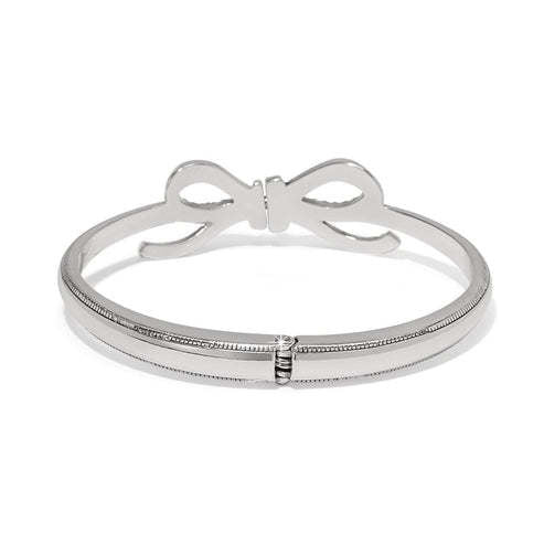 Silver hinged bangle featuring a delicate bow made of fine quality crystals with a shimmery finish.
