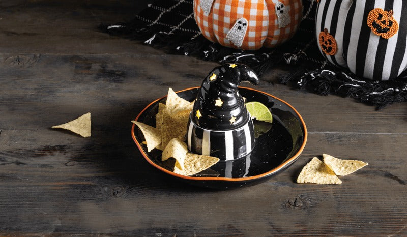 Light-up witch hat chip and dip set on a wooden table with tortilla chips and a lime wedge.