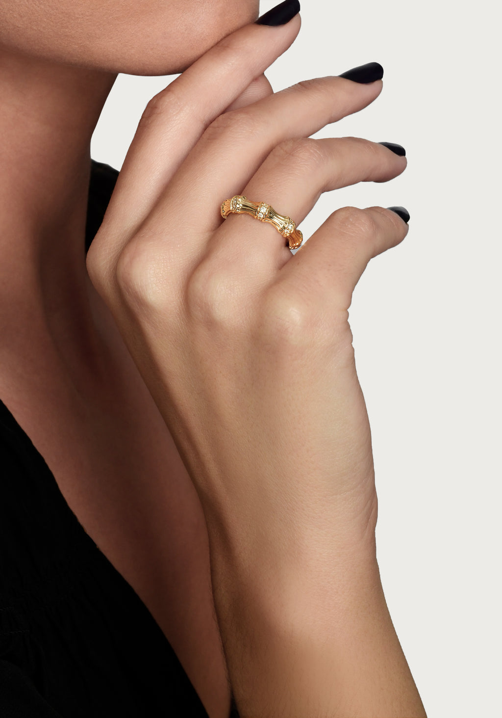 A person wearing the gold-plated Bamboo Single Ring with crystal pavé accents on their ring finger.