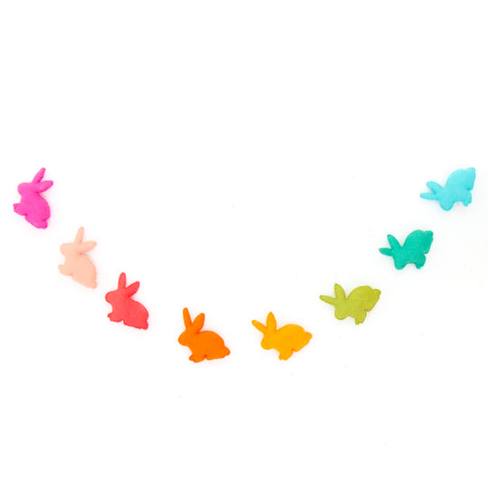 Rainbow felt bunny garland banner with eight colorful bunnies on a white background