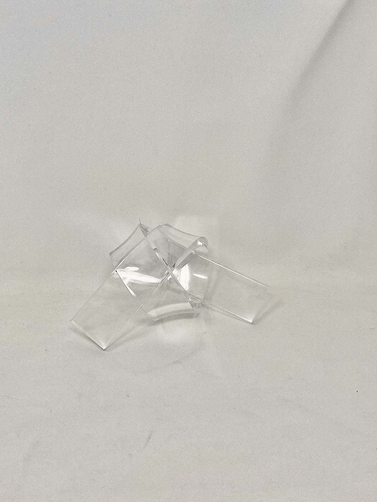 Acrylic knot pendant measuring three-eighths by one-and-a-half inches wide and twenty inches long.