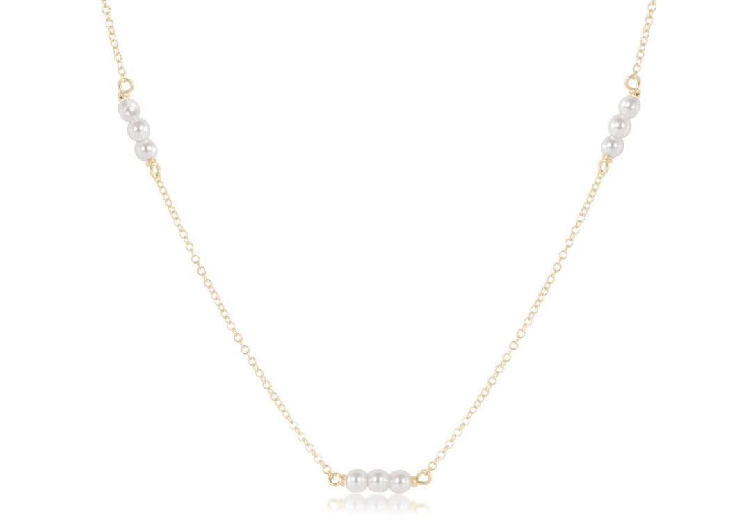 Gold-filled choker necklace featuring a delicate chain with three millimeter pearls.