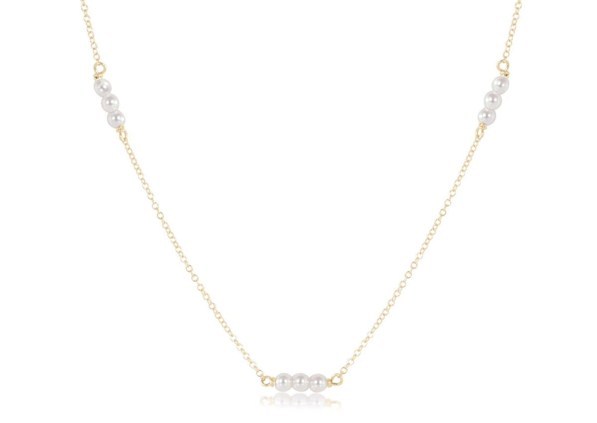 Gold-filled choker necklace featuring a delicate chain with three millimeter pearls.