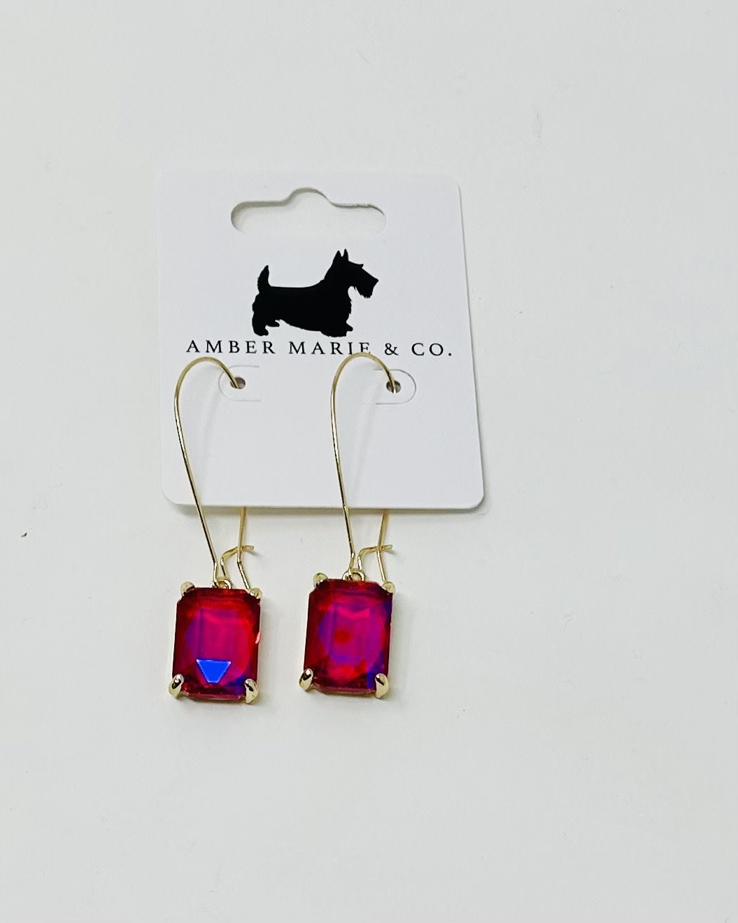 Rectangle drop earrings with vibrant pink-red faceted stones on gold-tone hooks.