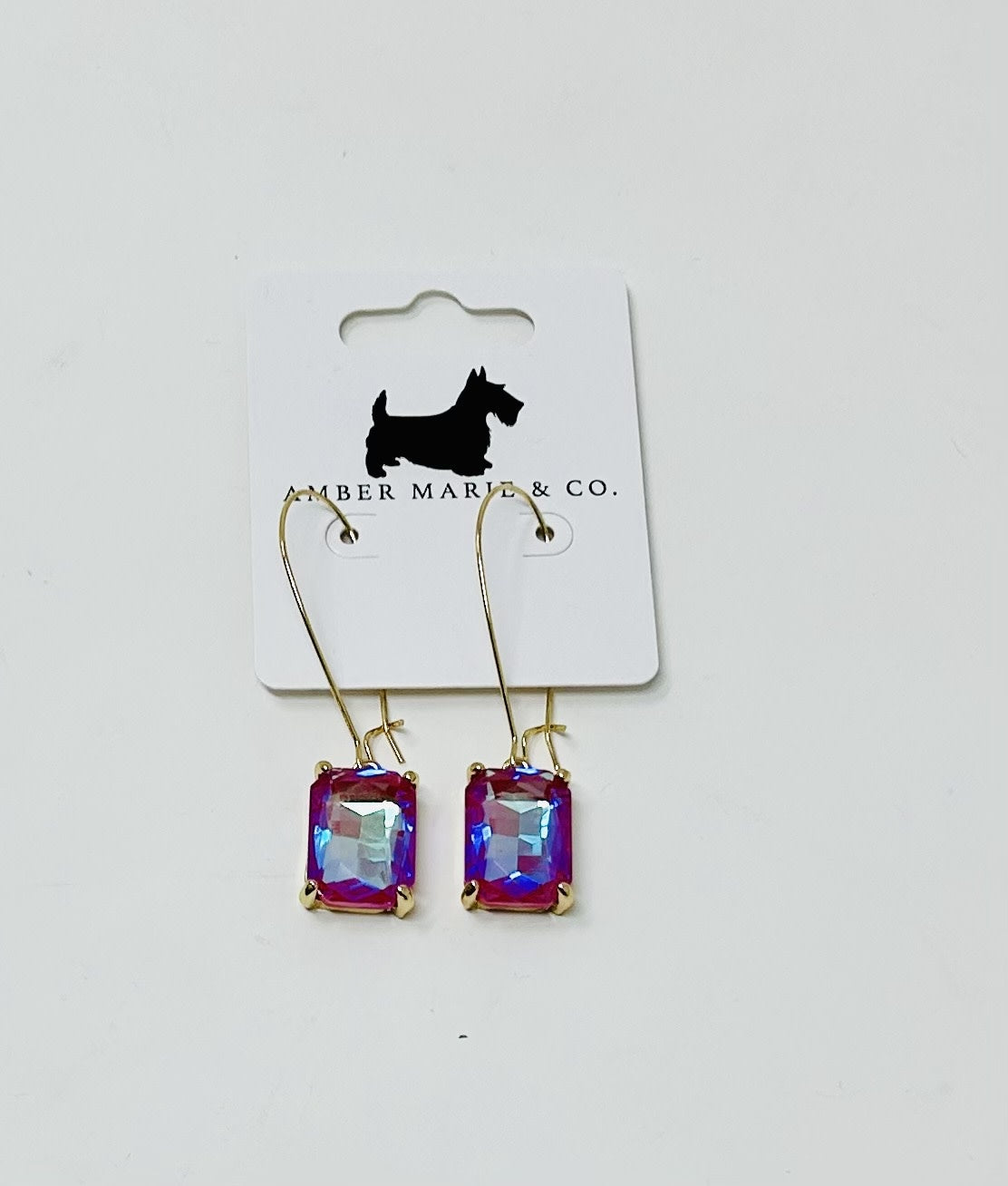 Gold-tone drop earrings featuring rectangular, iridescent pink and blue faceted crystals.