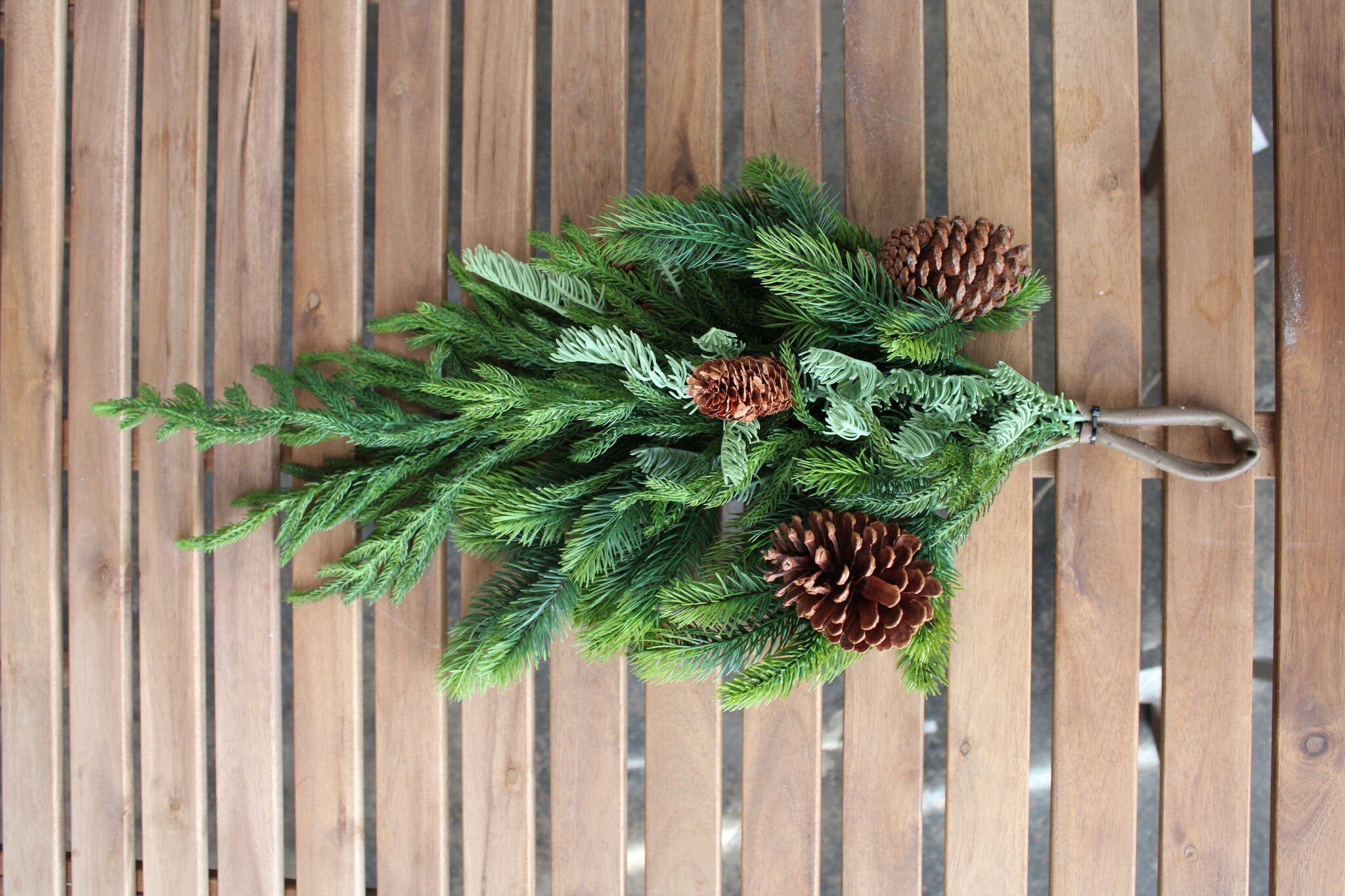 27-inch artificial Norfolk spruce and juniper teardrop swag with three pinecones.