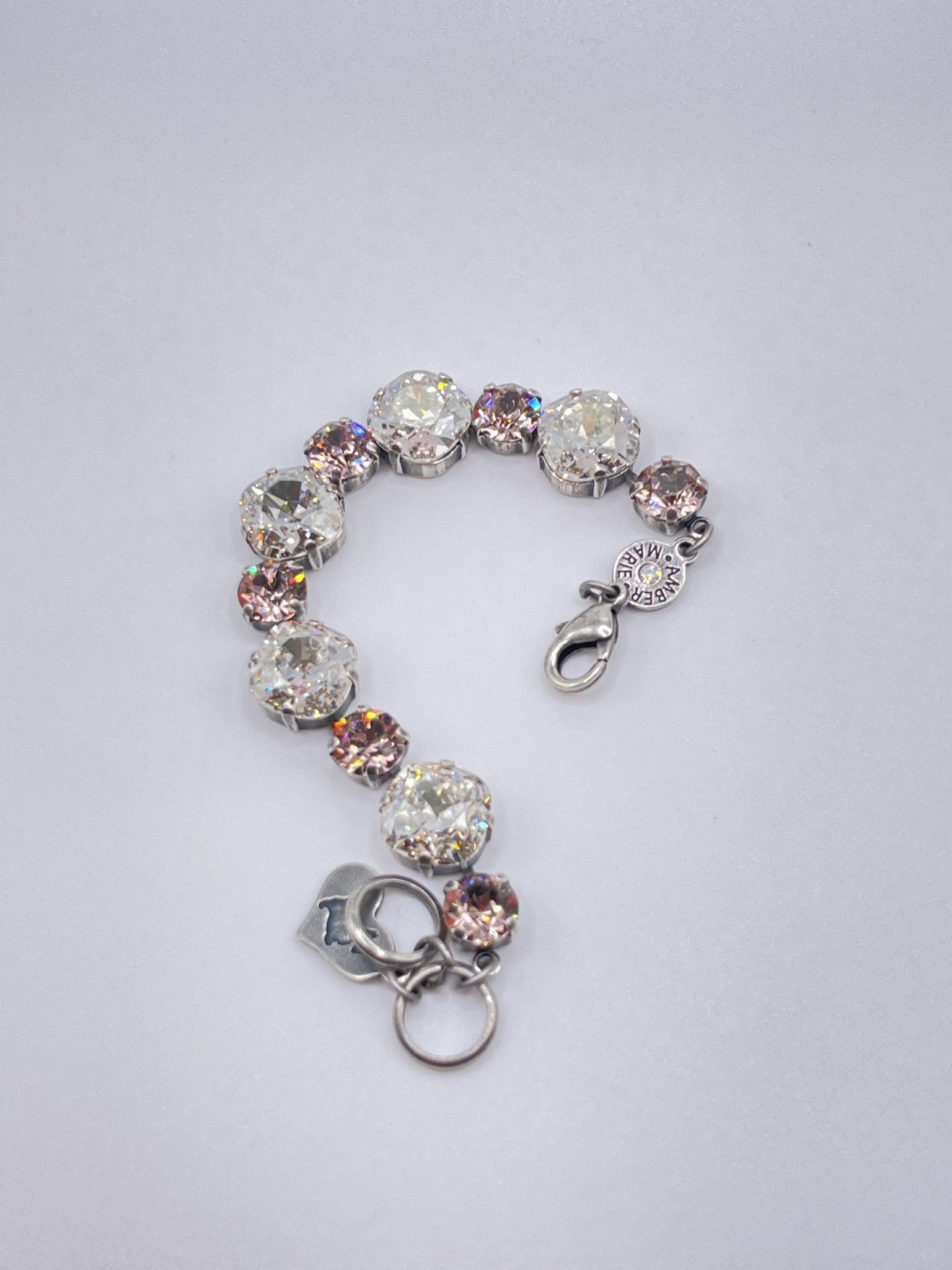 Silver-tone bracelet featuring alternating clear and pink crystal stones with a heart charm.