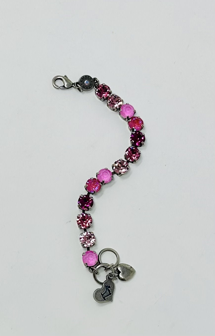 Milan bracelet featuring a strand of pink crystals in various shades with two small silver charms.
