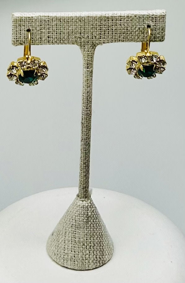Gold round stud earrings featuring a central stone with pave detailing.