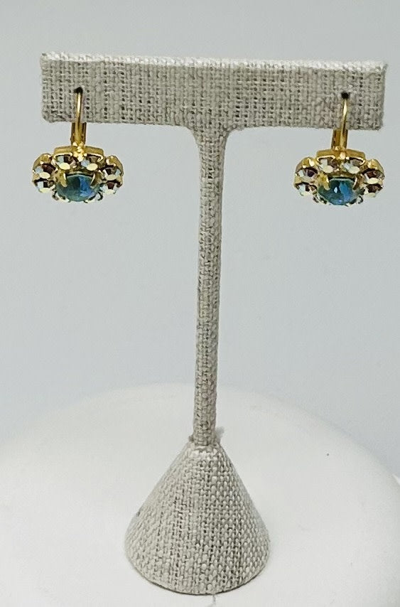 Gold round stud earrings featuring a central stone with pave setting.