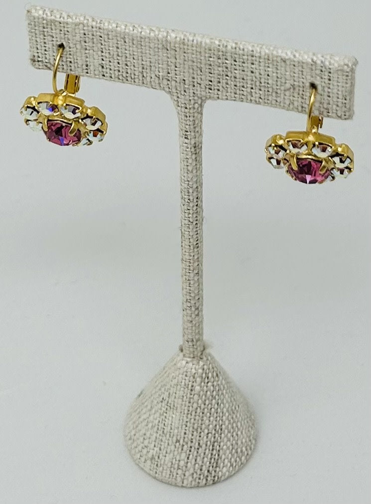 Gold round stud earrings featuring a central stone with pave detailing.