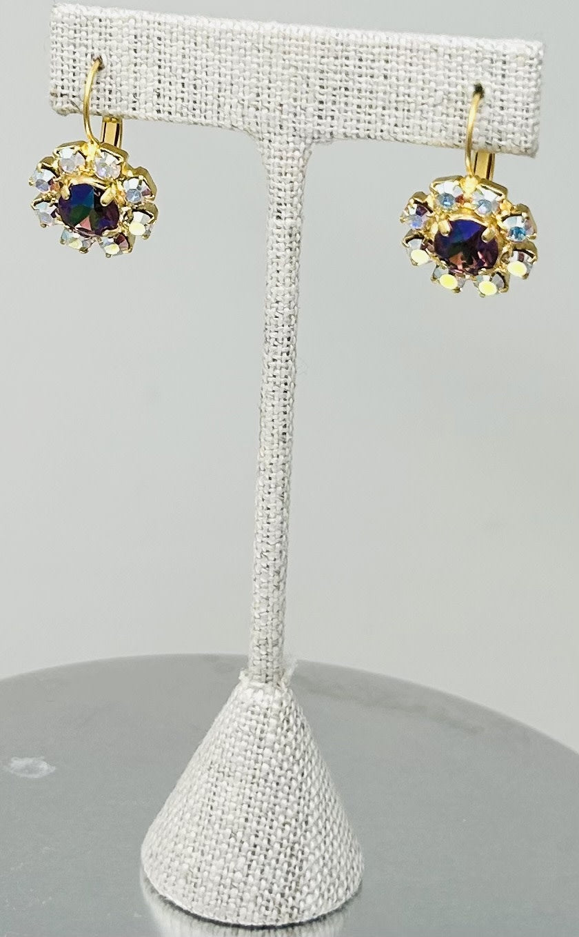Gold round stud earrings featuring a central stone with pave setting.