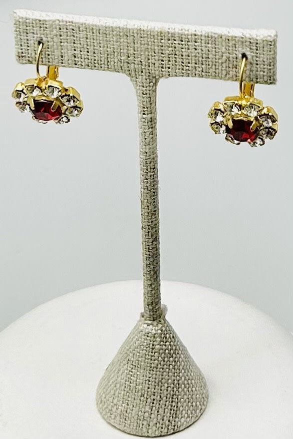 Gold round stud earrings featuring a central stone with pave setting.