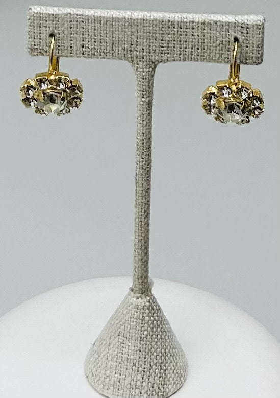 Gold round stud earrings featuring a central stone with pave detailing.