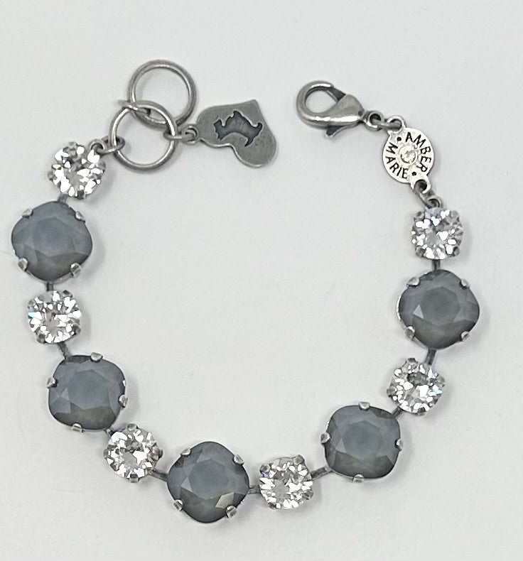 Silver-tone bracelet featuring alternating grey and clear crystal stones with a logo charm.