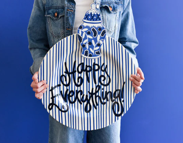Round ceramic serving platter with indigo skinny stripes and navy blue script text on a white background.