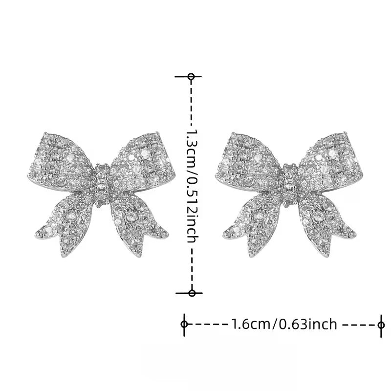 Sparkling rhinestone bow earrings with a silver-tone metal frame.