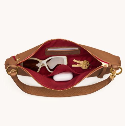 Kyle Med crossbody bag in warm medium brown pebbled leather with brushed gold hardware and red twill lining