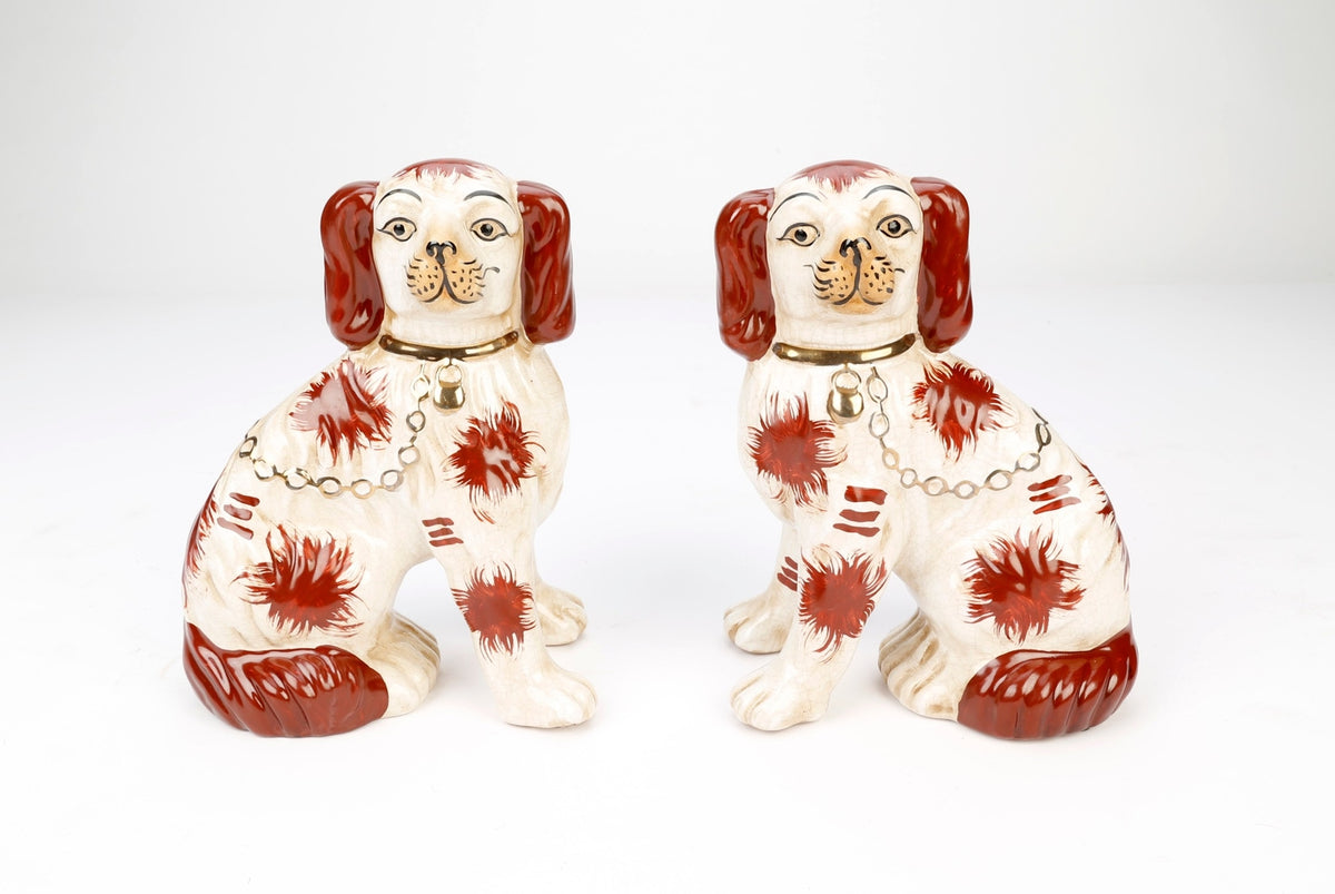 Pair of brown and white Staffordshire-style ceramic dogs with gold collars and chains.
