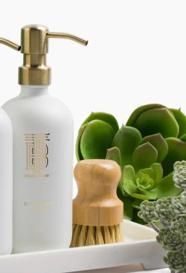 Glass hand soap dispenser with gold metal pump in Joshua Tree scent