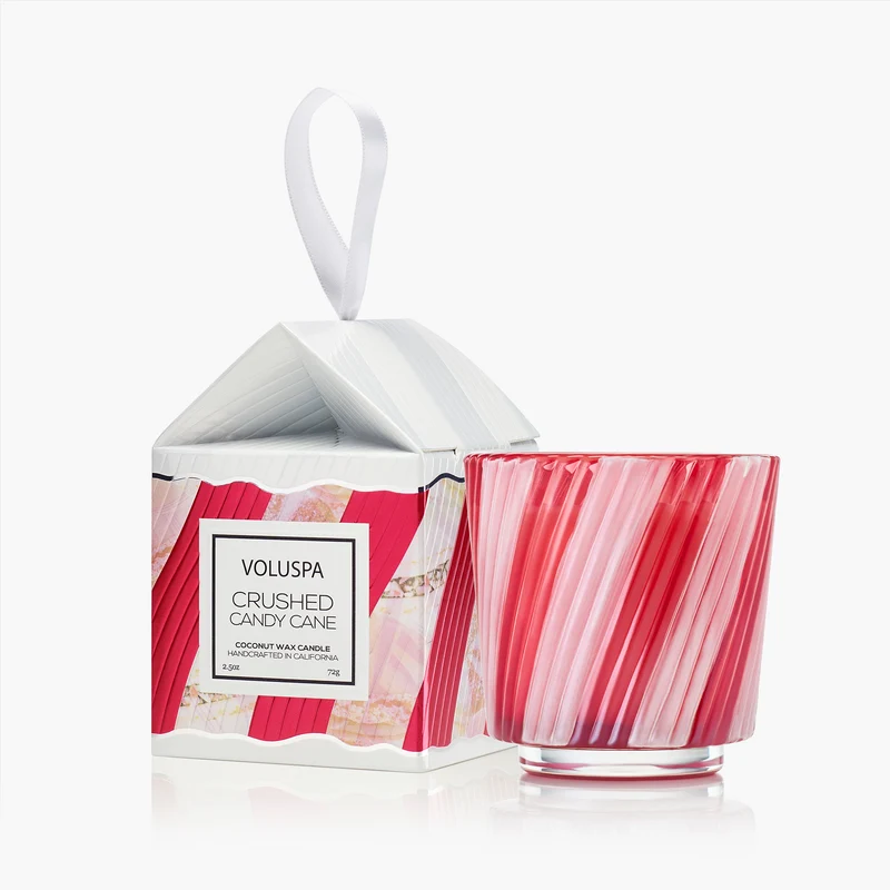 Voluspa Crushed Candy Cane 2.5oz candle in a red and pink swirled glass next to its ornament box.
