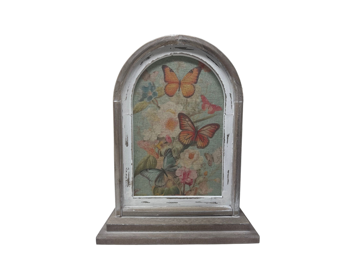 Rustic wood arch decoration featuring a floral and butterfly print on a burlap background.