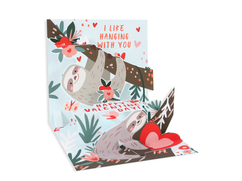 White Valentine's Day card with red foil sloth illustration reading 'I like hanging with you' inside a white envelope.