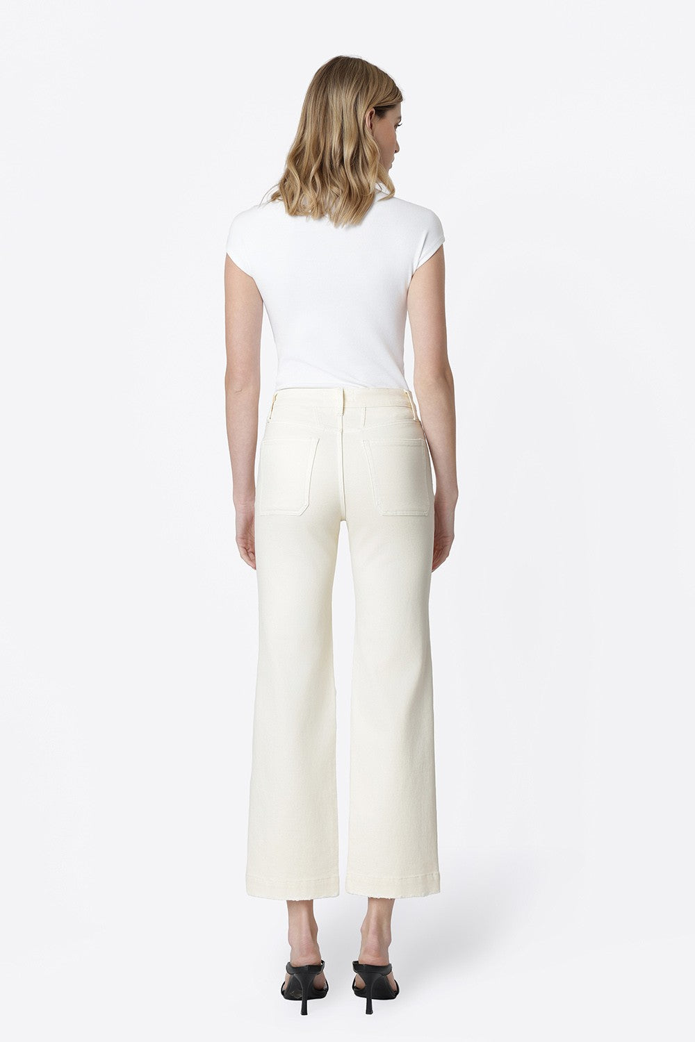 Back view of a woman wearing Ailleah high-rise slim wide leg jeans in natural white.