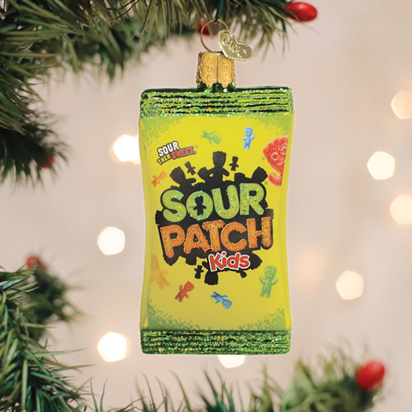 Glass Sour Patch Kids candy bag Christmas ornament hanging on a tree branch.