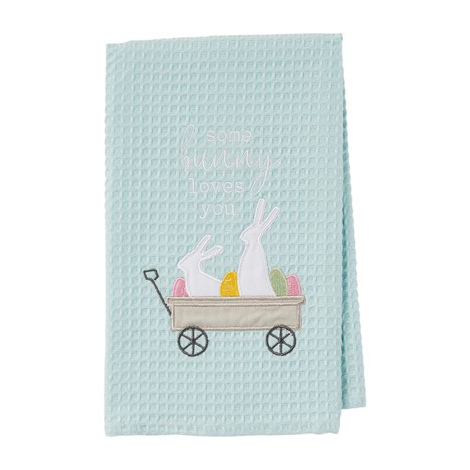 Light blue waffle weave towel with embroidered Easter bunnies and eggs in a wagon.