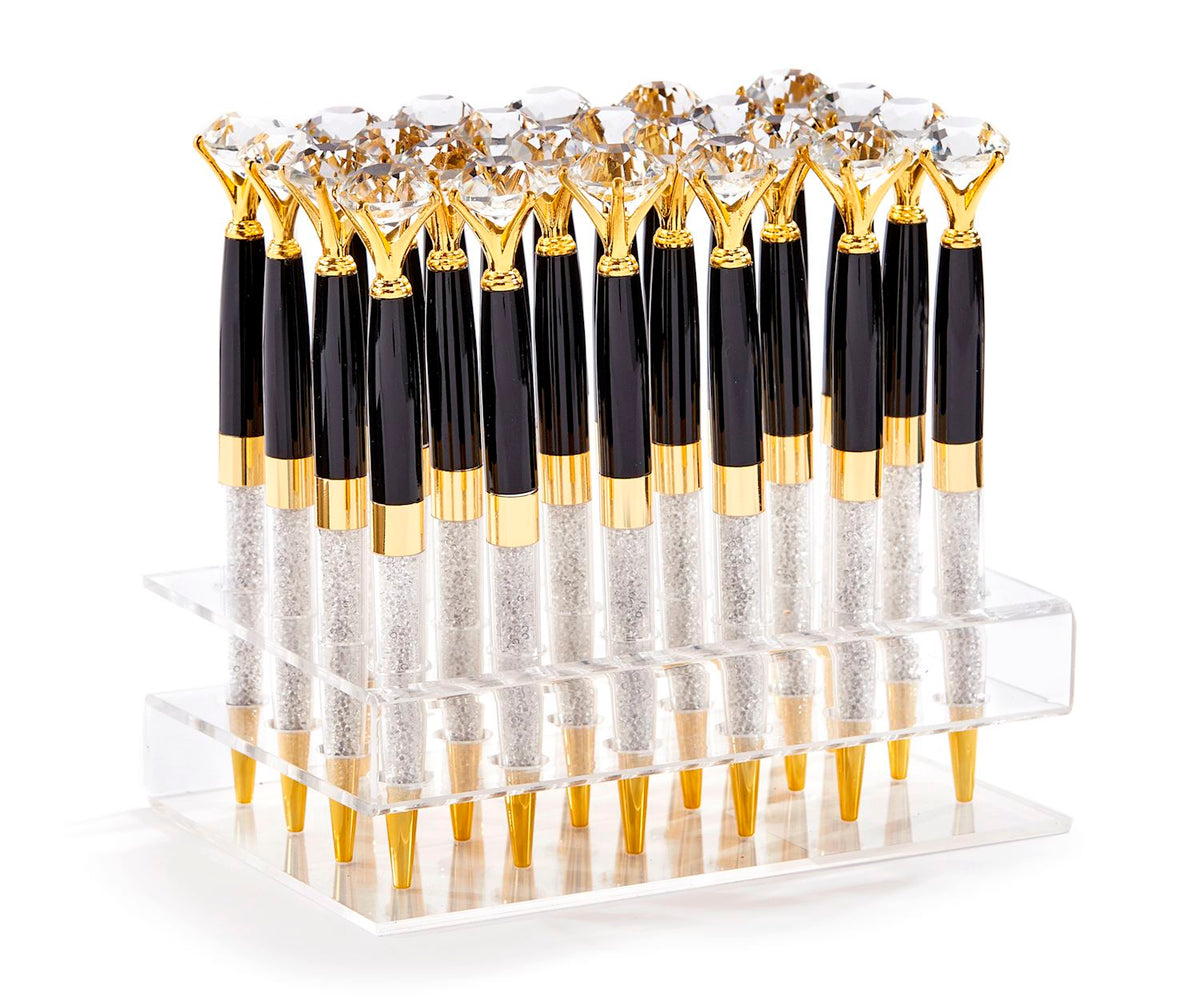 Black and gold diamond-topped pens with crystal-filled barrels in a clear acrylic display stand.