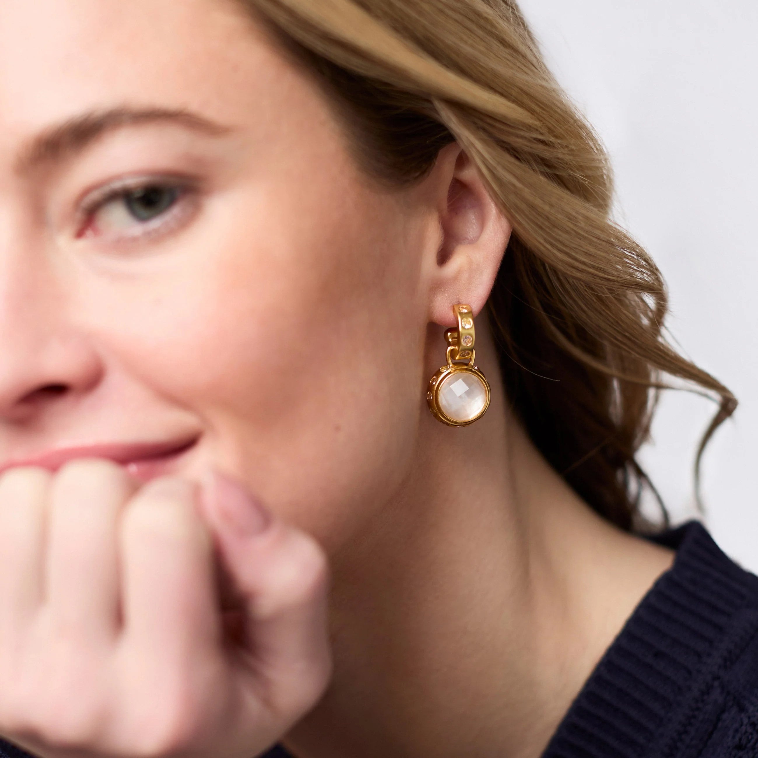 Woman wearing a Rainbow Hoop & Charm Earring in 24K gold plate with a round white glass charm.