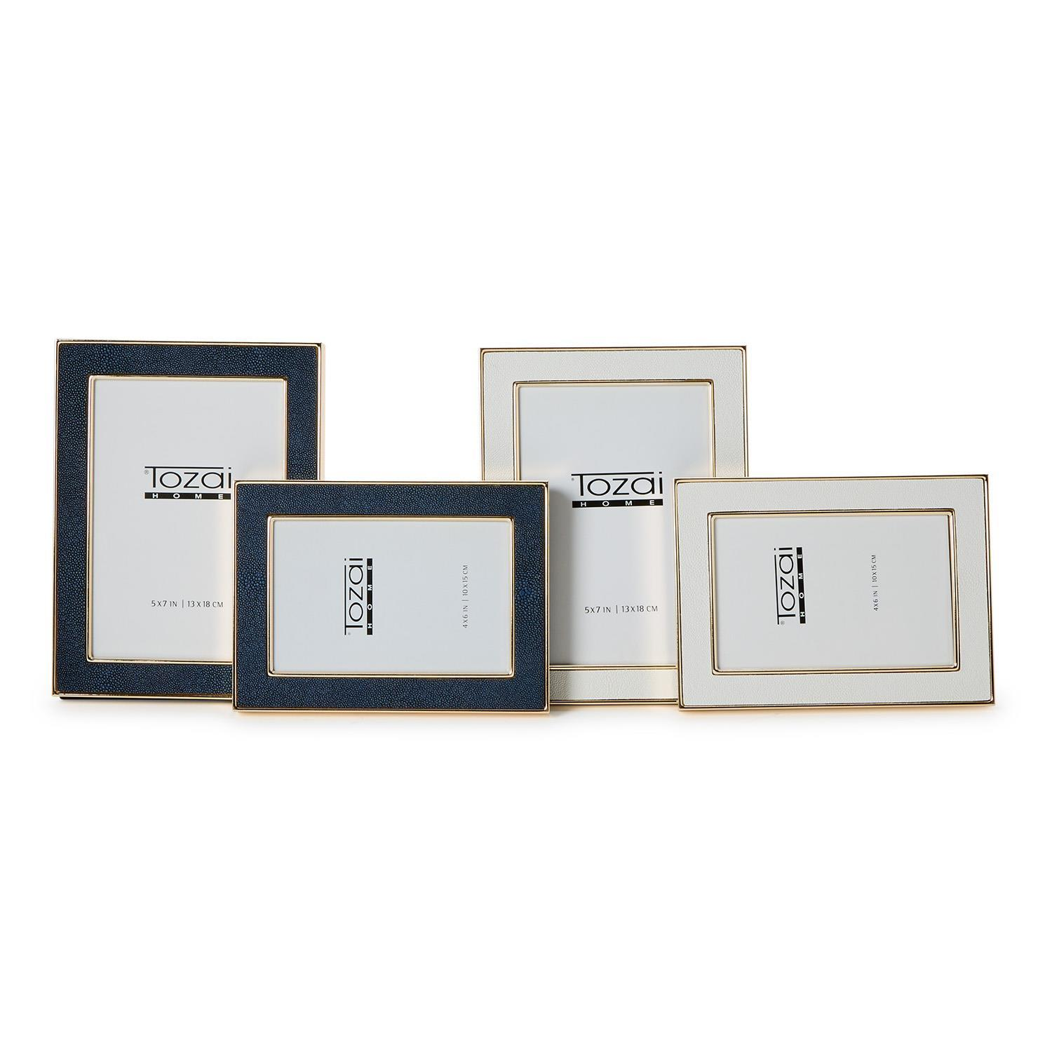 Four Astor Shagreen photo frames in navy and cream, shown in 4x6 and 5x7 sizes with gold trim.