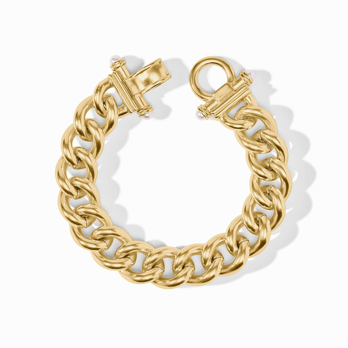 Gold link bracelet with a fold-over clasp and small pearl accents.