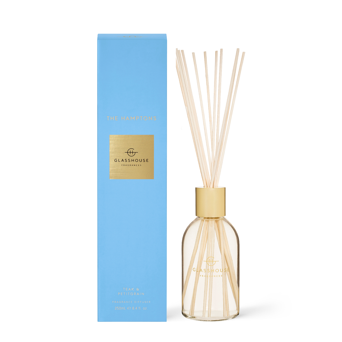 Glasshouse The Hamptons diffuser with amber liquid and reeds in a clear glass bottle.
