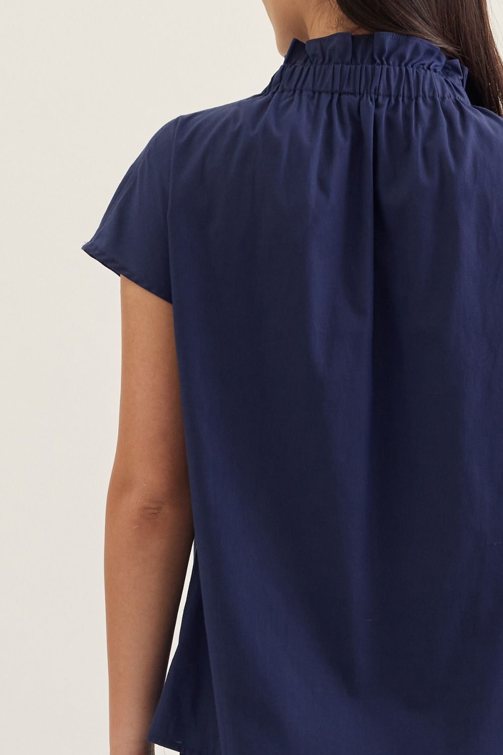 Aliana solid cap sleeve top in light beige with ruffled stand collar and button front closure