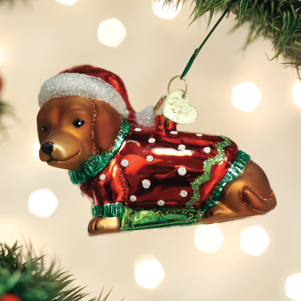 Dashing Dachshund Puppy Ornament wearing a red Santa hat and a festive red and green sweater.
