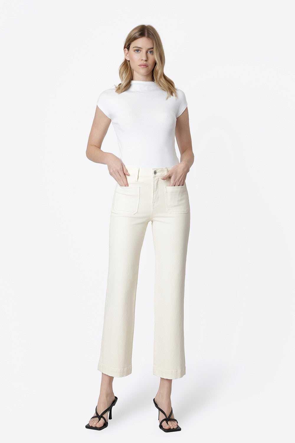 Woman wearing Ailleah high-rise slim wide leg jeans in natural color with front patch pockets.