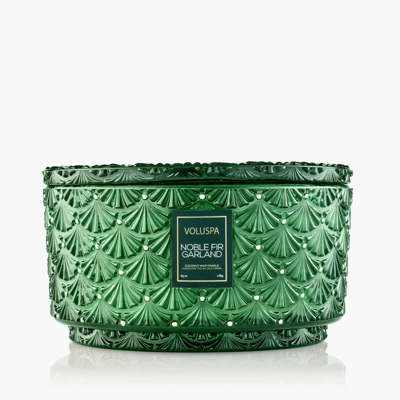Voluspa Noble Fir Garland Centerpiece Candle in a green embossed glass jar with a lid.