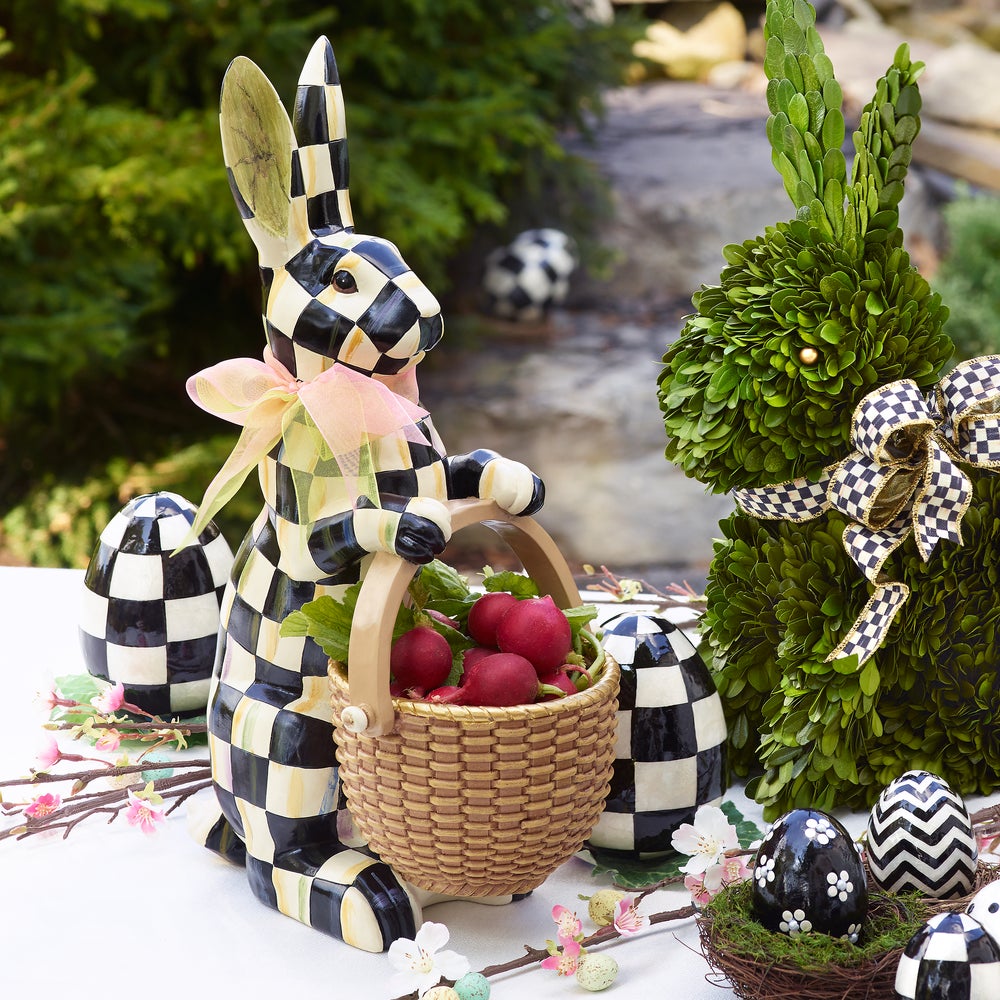 Courtly Check Rabbit resin figurine holding a basket of radishes next to a topiary bunny.