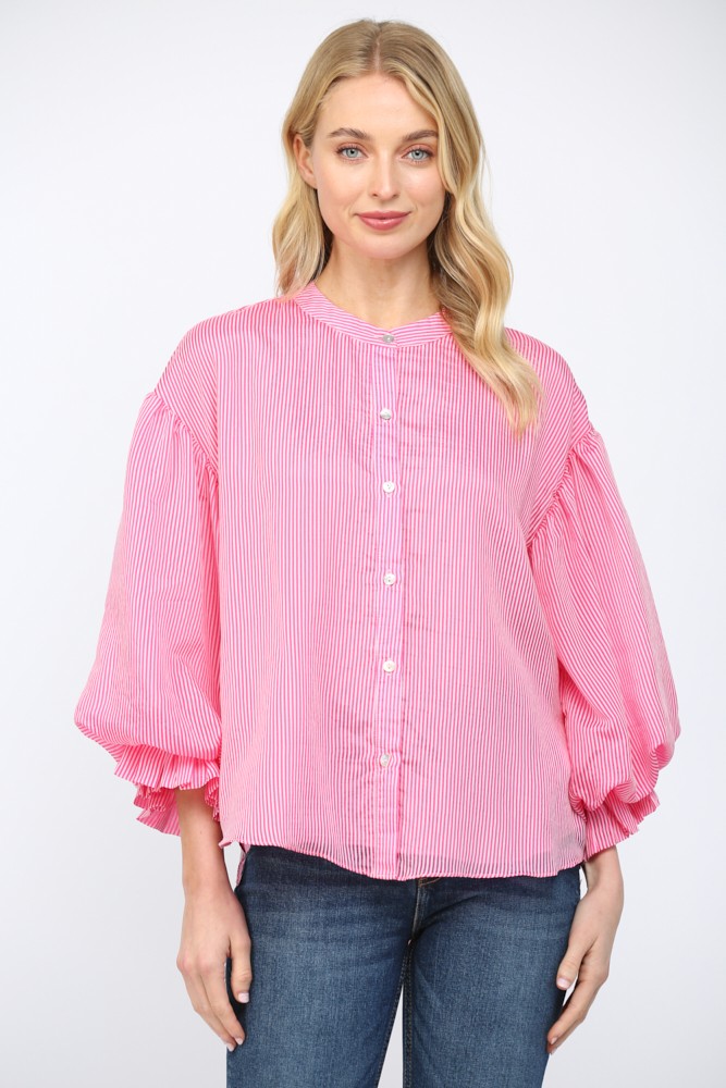 Woman wearing a pink and white pinstripe blouse with voluminous bubble sleeves and button front.