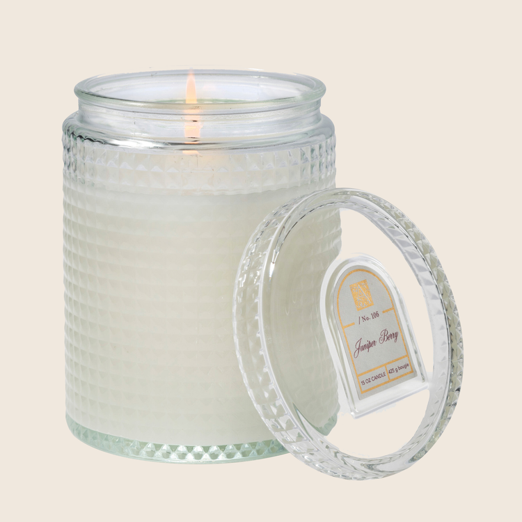 15 oz Juniper Berry candle in a textured glass jar with a lit wick and matching glass lid.