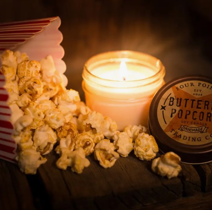Buttered Popcorn soy candle in a clear glass jar with an off-white wax and beige label.