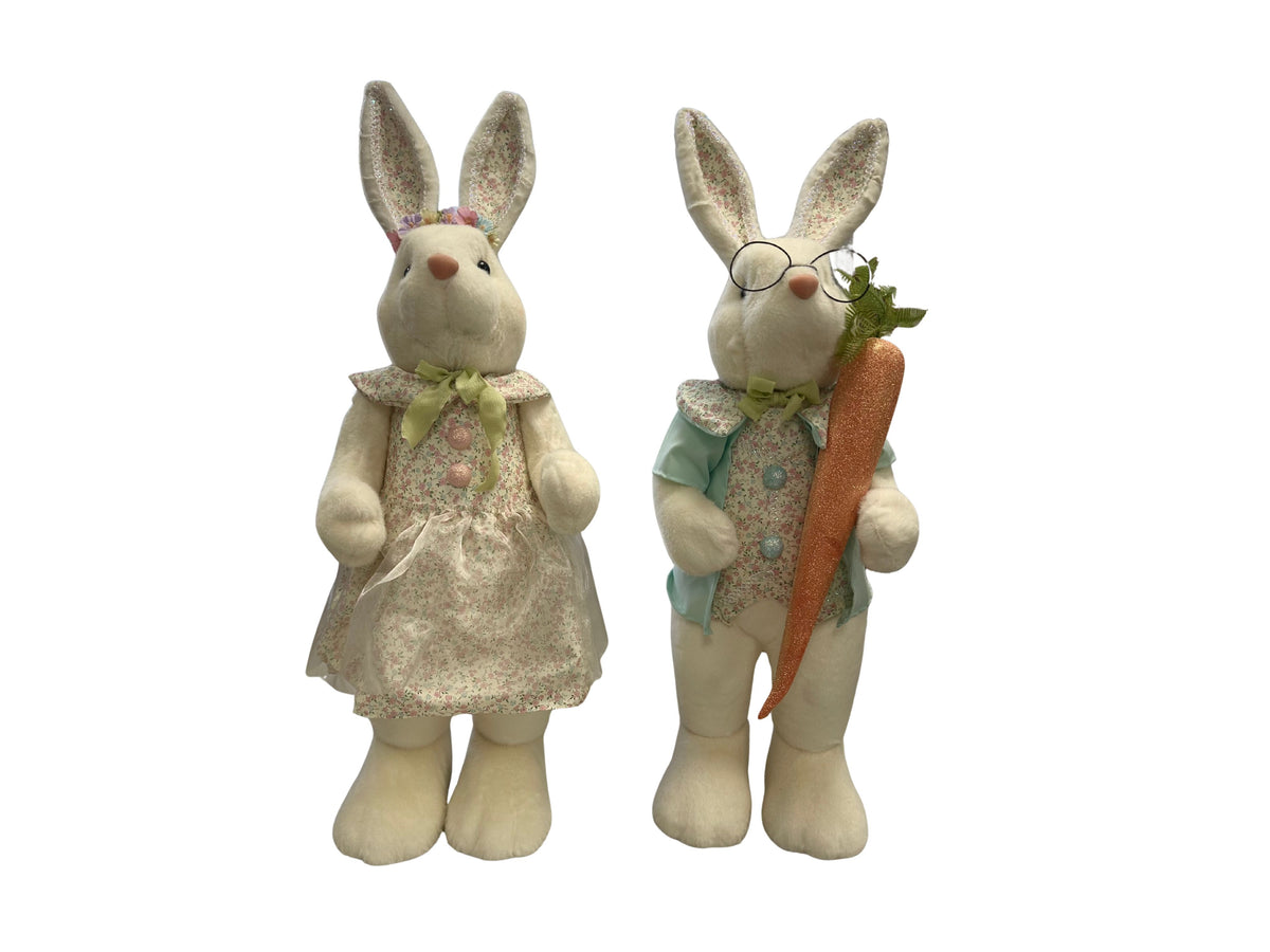Two large plush Easter bunnies, one in a floral dress and one in a vest holding a glittery carrot.