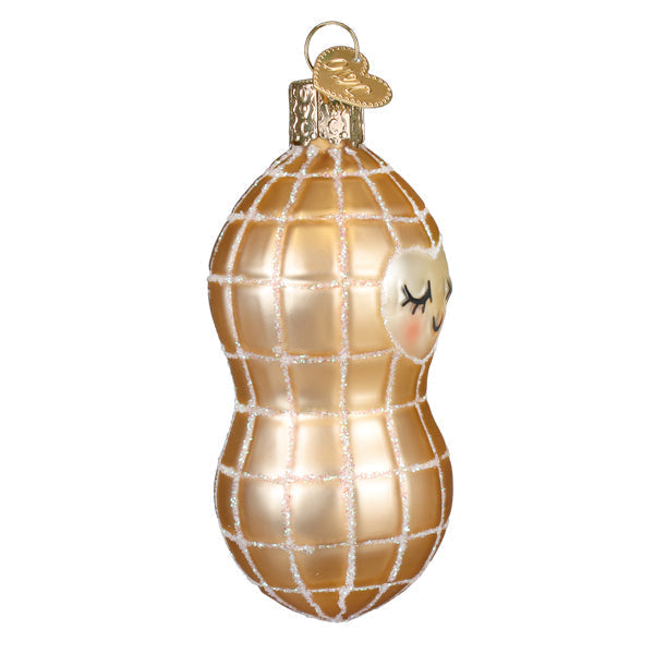 Gold glass peanut ornament with a smiling face, glitter accents, and a heart-shaped metal tag.