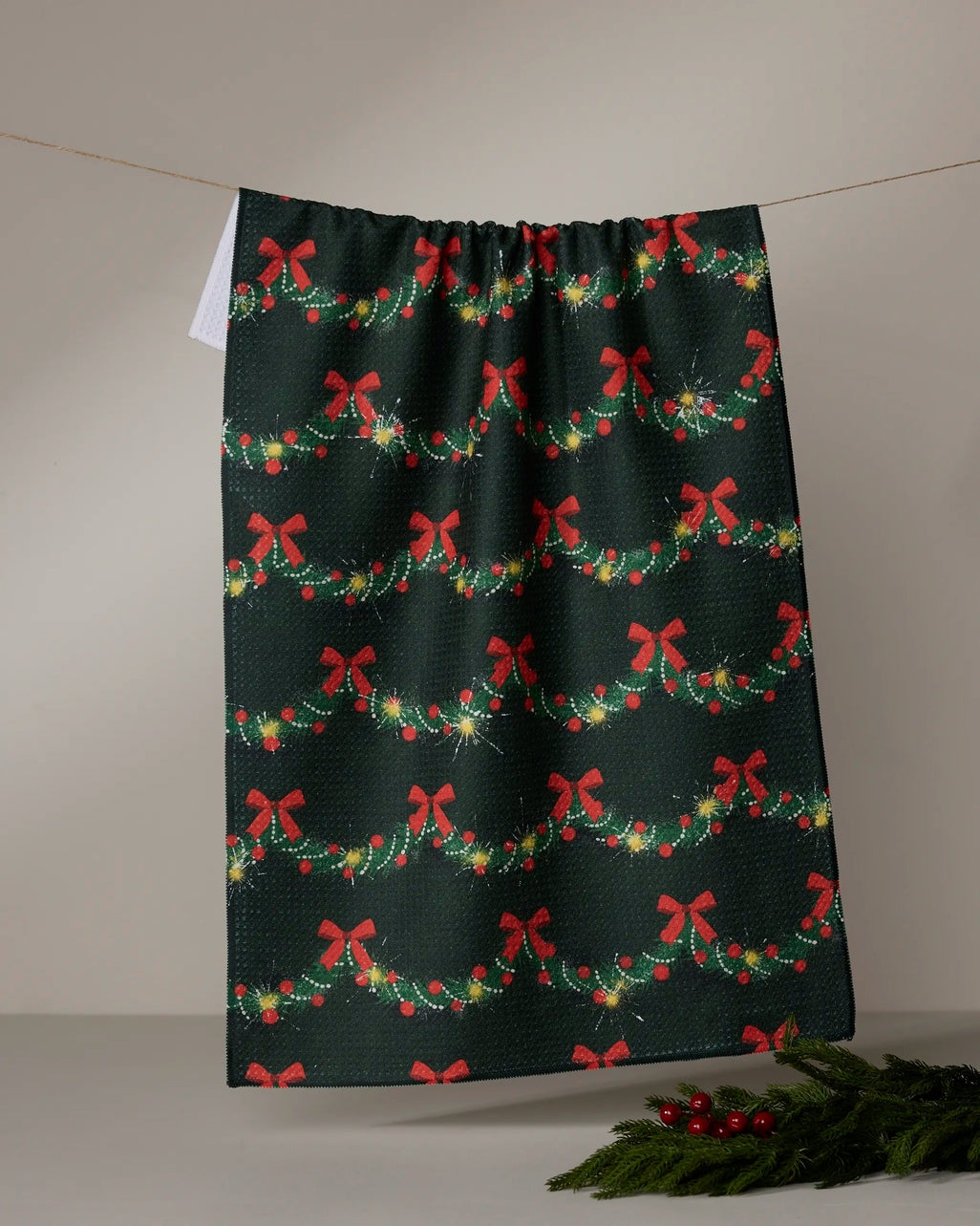 Holiday tea towel with waffle weave construction in festive red featuring a snowman pattern and hang loop.